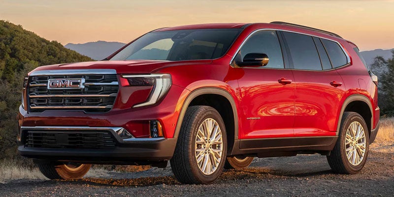 Red 2026 GMC Acadia SUV showcasing bold exterior styling and signature LED lighting at Escamilla GMC
